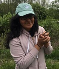 Raquel Castromonte in a pink jacket holding an adult bird.